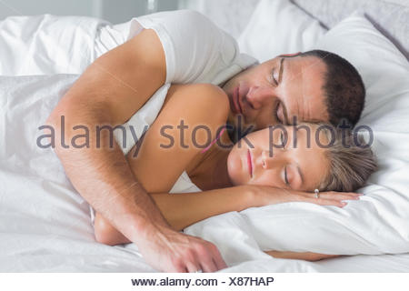 Cute Couple Sleeping And Cuddling In Bed At Home In Bedroom