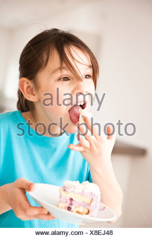 A Little Girl Nibbling On A Piece Of Cake Stock Photo Alamy