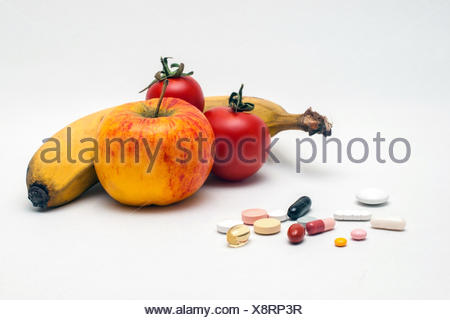 verschiedene bunte Tabletten, Apfel, Banane und Tomaten, isoliert