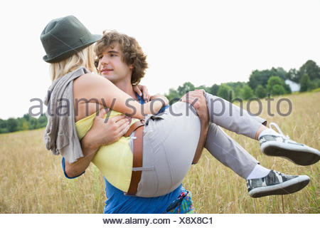 https://l450v.alamy.com/450v/x8x8c1/romantic-man-carrying-woman-in-field-x8x8c1.jpg