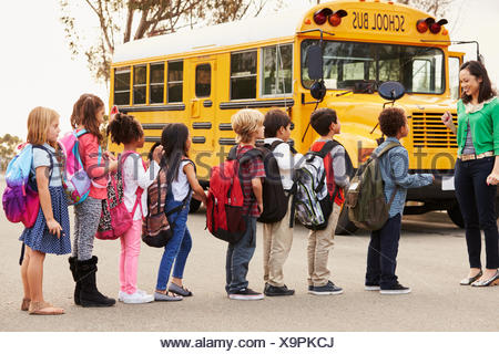 Children and teacher by school bus Stock Photo: 28014775 - Alamy