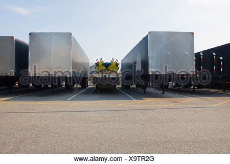 Semi truck in parking lot hauling 3 more tractors piggy back style ...