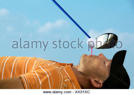 Man balancing golf ball on tee in his mouth