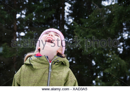 portrait of girl catching snow flakes on tongue in front yard Stock ...