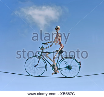 Human skeleton cycling on a wire rope Stock Photo - Alamy