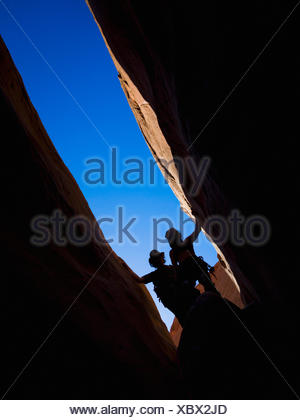 Adventurers exploring a desert slot canyon; Hanksville, Utah, United States of America