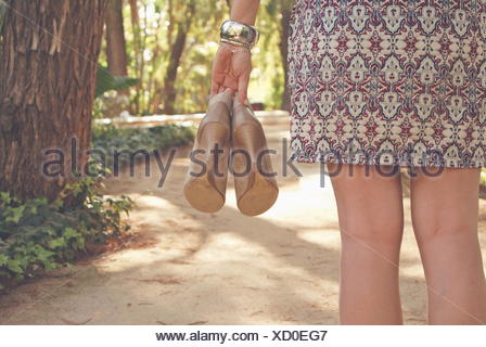 Rear view of a woman holding pair of shoes