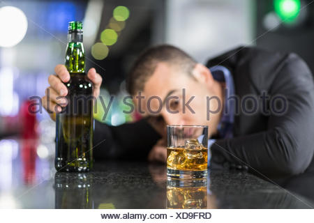 Drunk man slumped on bar asleep Stock Photo - Alamy