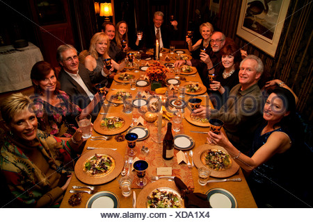 Thanksgiving toast at long dinner table before ...
