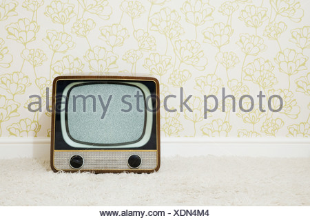 Retro television in room with patterned wallpaper