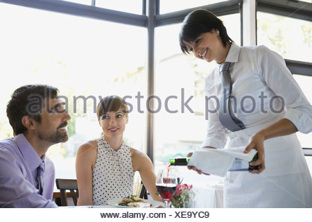 https://l450v.alamy.com/450v/xe9yc9/waitress-serving-red-wine-to-professional-couple-in-restaurant-xe9yc9.jpg