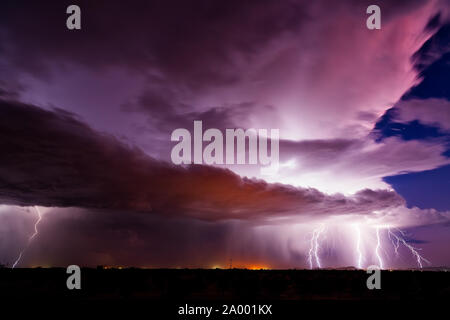 Dramatischer Sonnenuntergangshimmel mit Blitzen, die von einer Monsun-Gewitterwolke in der Wüste in der Nähe von Wintersburg, Arizona, getroffen wurden Stockfoto