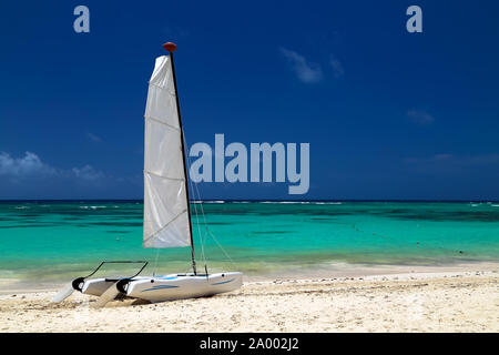 Katamaran auf der exotischen Küste des Atlantischen Ozean mit einem Hintergrund von goldenen Sand des smaragdgrünen Wasser und den blauen Himmel. Wunderschöne Karibische Meer, Pan Stockfoto