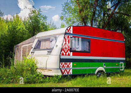 Ein PKW-Anhänger, Wohnmobil, in der nationalen Flagge von Belarus steht in einer bergigen geparkt gemalt. Das Konzept des Straßenverkehrs, der Handel, Export und Stockfoto