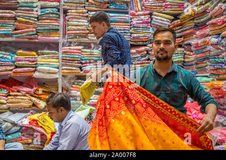 Eine indische Sari Verkäufer in einem Geschäft in Chandni Chowk Markt in Neu Delhi, Indien Stockfoto