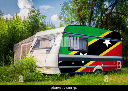 Ein PKW-Anhänger, Wohnmobil, in der nationalen Flagge von Saint Kitts und Nevis liegt in einer bergigen geparkt gemalt. Das Konzept der Straßenverkehr, tr Stockfoto