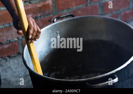 Hand eines Andinen Mann bewegen Der Holzlöffel in einem Topf, Anden rustikale Küche Stockfoto