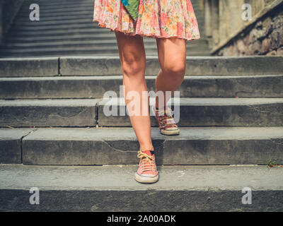 Die Beine einer jungen Frau zu Fuß einige Treppen außerhalb in einer Stadt Stockfoto