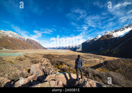 Weite und Größe winter Bergwelt Blick von oben. Tasman Valley mit Schnee bedeckten Bergen und Frau an Landschaft suchen. Neuseeland Stockfoto