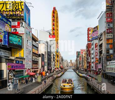 Touristenboot auf dem Dotonbori Canal, beleuchtete Werbung und viele Zeichen, Dotonbori, Osaka, Japan Stockfoto