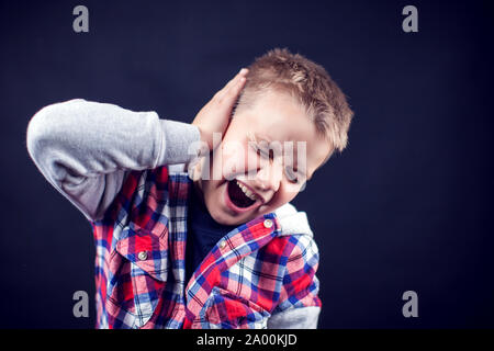 Ein Junge fühlt sich starke Ohrenschmerzen. Kinder, Gesundheitswesen und Medizin Konzept Stockfoto