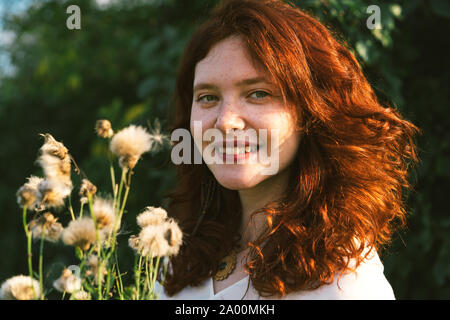 Schöne junge Frau mit roten lockigen Haar und Sommersprossen im Gesicht. Stockfoto