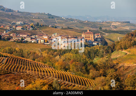 Blick auf bunte herbstliche Weinberge und die kleine Stadt von Barolo auf Hintergrund in Piemont, Norditalien. Stockfoto