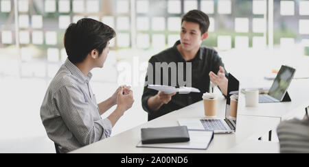 Zwei professionelle Geschäftsleute über ihre Fortschritte Ihres aktuellen Projekts im Tagungsraum Stockfoto