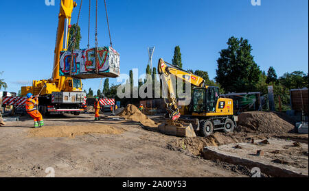 Berlin, Deutschland. 19 Sep, 2019. Ein Kran hebt ein granitblock im Mauerpark wieder an seinen Platz. Die granitblock und ein Tank barrier hatte für die Arbeit der Wasserwerke am Behälter Kanal, Abfall, Wasser zu speichern, verschoben. Credit: Andreas Gora/dpa/Alamy leben Nachrichten Stockfoto