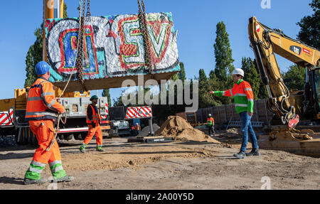 Berlin, Deutschland. 19 Sep, 2019. Ein Kran hebt ein granitblock im Mauerpark wieder an seinen Platz. Die granitblock und ein Tank barrier hatte für die Arbeit der Wasserwerke am Behälter Kanal, Abfall, Wasser zu speichern, verschoben. Credit: Andreas Gora/dpa/Alamy leben Nachrichten Stockfoto