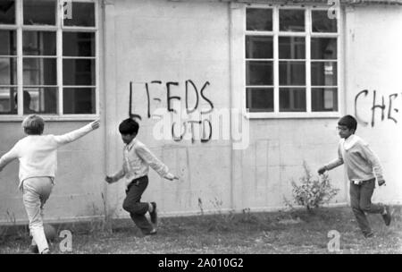 Southall, London 1972. Jungen Fußball spielen von Graffiti. Nach Idi Amin bestellt 30.000 Asiaten aus Uganda mit 90 Tagen, die mit britischen Pässen zu England geleitet. Sie wurden gezwungen, ihr Geld, Eigentum und Besitz hinter sich zu lassen. Diese Bilder dokumentieren das Leben für einige dieser Menschen, wie sie in Southall, westlich von London nieder. Einen Einblick in das Leben vor 47 Jahren für Einwanderer in Großbritannien. Foto von Tony Henshaw Stockfoto