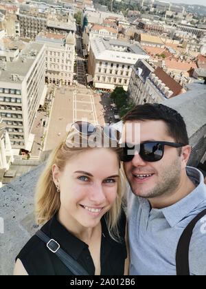 Foto des glücklichen Paares auf Spaziergang in der Stadt gegen den Hintergrund der Attraktionen am Tag Stockfoto