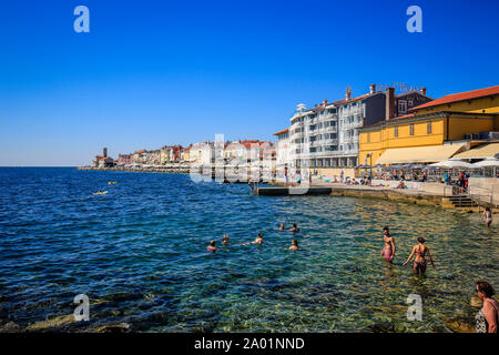 Piran, Istrien, Slowenien - Leben am Strand am Strand der Stadt der Hafenstadt Piran am Mittelmeer. Piran, Istrien, Slowenien - Strandleben am Sta Stockfoto