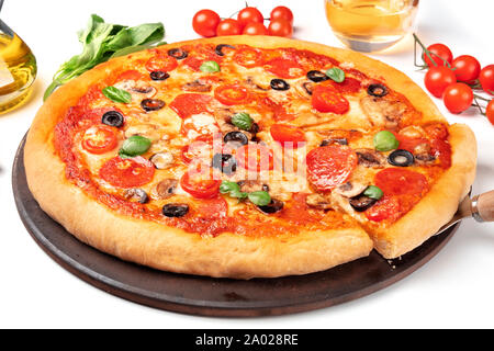 Pepperoni Pizza mit Salami Scheiben, schwarze Oliven, Champignons, frische Basilikumblätter und viel Käse Stockfoto