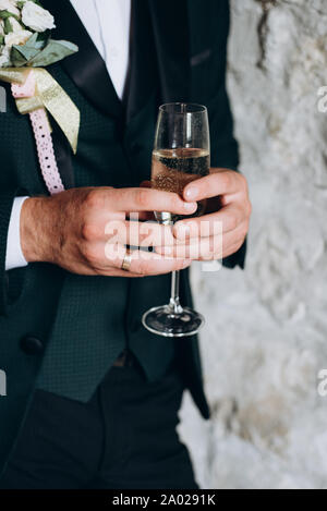 In der Nähe von Groom hält ein Glas Champagner. Party und Urlaub feier Konzept Stockfoto