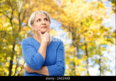 Portrait der älteren Frau denken im Herbst Park Stockfoto