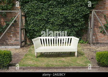Isoliert weißer Sitzbank in Country Garden Stockfoto