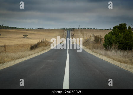 Lange gerade Straße überschrift in ominösen Wolken in Portugal Stockfoto