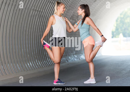 Frauen mit Fitness tracker Stretching im Freien Stockfoto