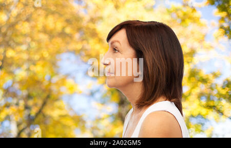 Profil von älteren Frau über Bäume im Herbst Stockfoto