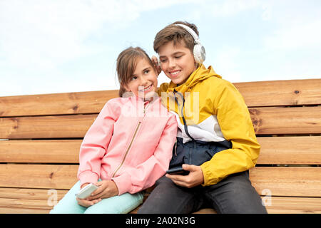 Bou und Mädchen mit Kopfhörer Musik hören Stockfoto