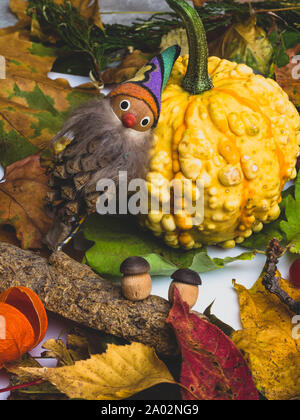 Herbst Hintergrund mit bunt gemischten Blätter, Kürbis, Beeren, Cydonia, Physalis und Märchenhaften gnome und Pilze aus Holz. Mockup für saisonale aus Stockfoto