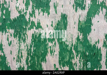 Peeling grüne Farbe auf einem Brett an der Wand. Stockfoto