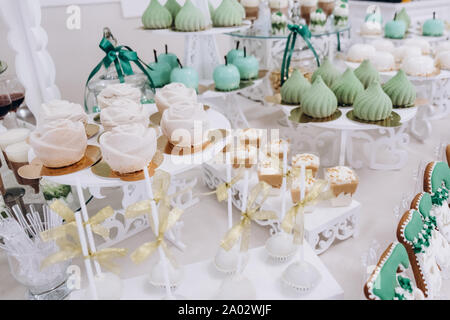 Hochzeit Dekoration mit bunten Muffins, Eclairs, souffle, Baisers, Muffins. Elegante und luxuriöse Veranstaltung Anordnung mit Süßigkeiten. Hochzeit Dessert Stockfoto