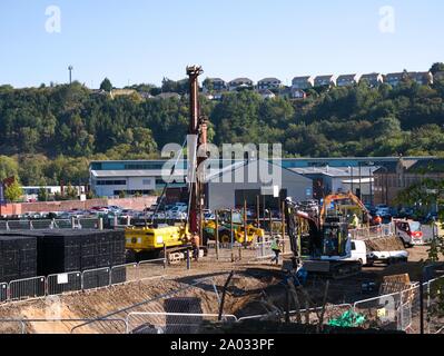 Ramme und anderen Bau Maschinen und Menschen arbeiten auf einer Baustelle in Huddersfield Yorkshire Engkand Stockfoto