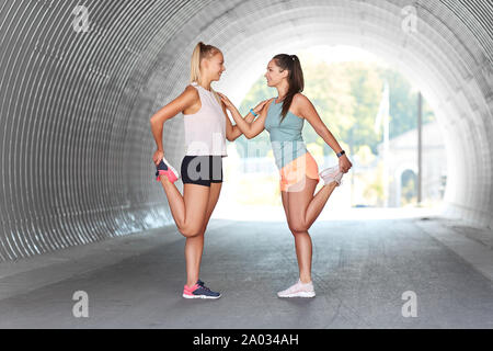 Frauen mit Fitness tracker Stretching im Freien Stockfoto