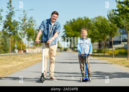 Vater und Sohn reiten Roller in Stadt Stockfoto