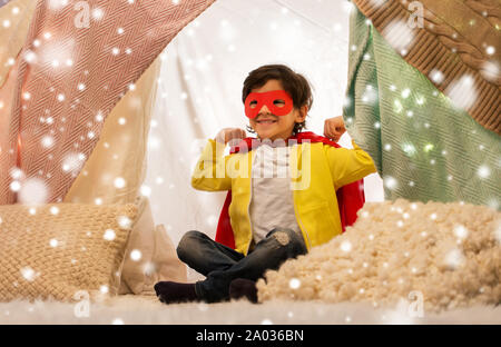 Happy Boy in super hero Cape in Kinder Zelt zu Hause Stockfoto