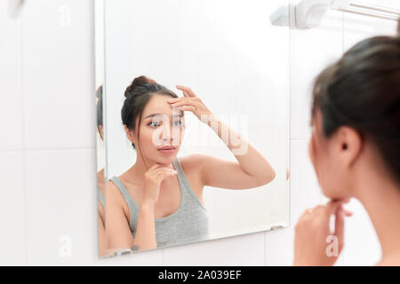 Frau Anwendung Gesichtscreme nach der täglichen Dusche. Die täglichen morgendlichen Routine im Badezimmer. Stockfoto