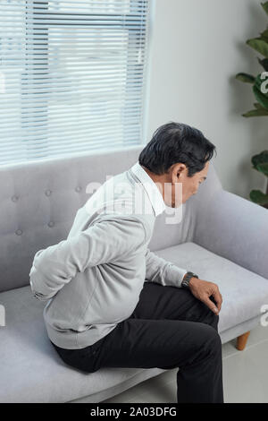 Menschen, Gesundheitswesen und Problem Konzept - unglücklich ältere Menschen leiden unter Schmerzen im Rücken oder Zügel zu Hause Stockfoto